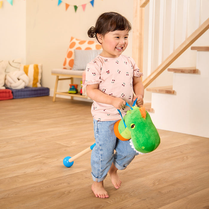green dino hobby horse with wooden riding pole