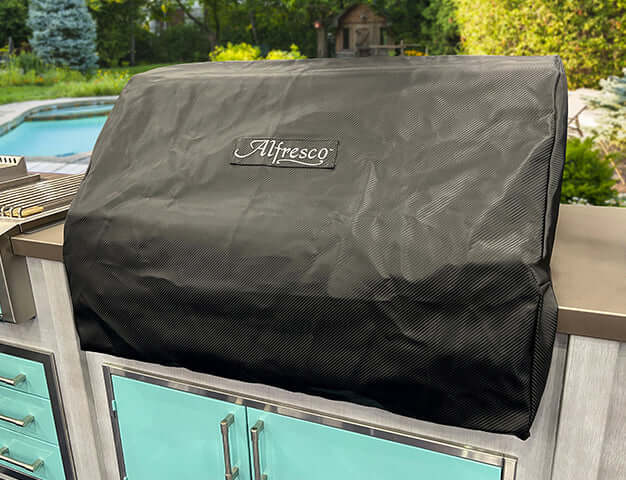 Alfresco Premium 36 inch grill cover protecting built-in grill from the elements in outdoor kitchen.