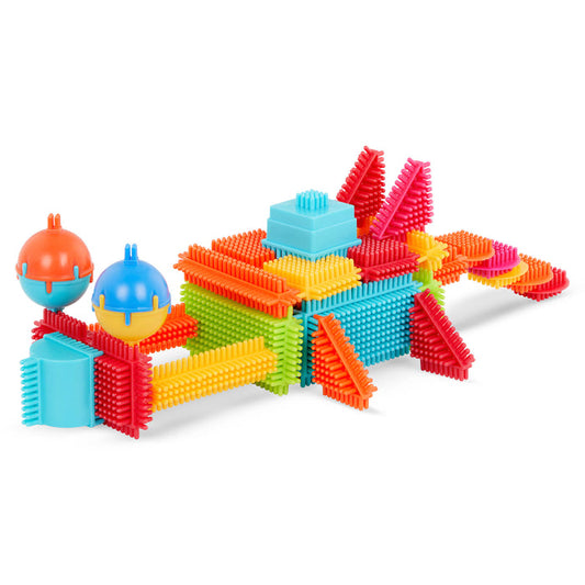 A colorful array of Bristle Blocks laid out so we can see all the pieces and the big reusable storage container.