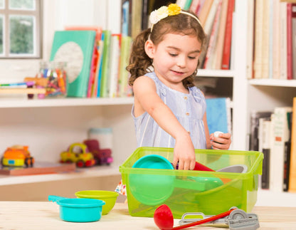 A toy cooking set with a huge variety of different tools in a green bin.