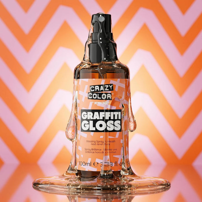 a texture visual of Crazy Color Graffiti Gloss Glossing Spray 100ml with the liquid leaking out the spray lid going down onto the product and a puddle of liquid at the bottom on a pink and orange triangular patterned background